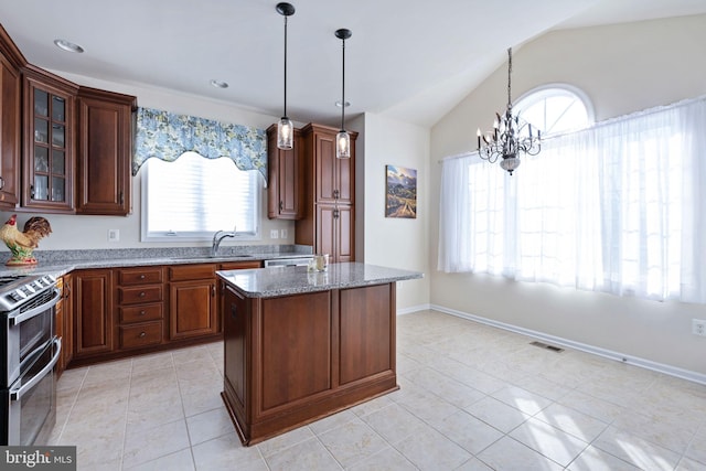 kitchen with light stone counters, stainless steel range, vaulted ceiling, a chandelier, and a center island