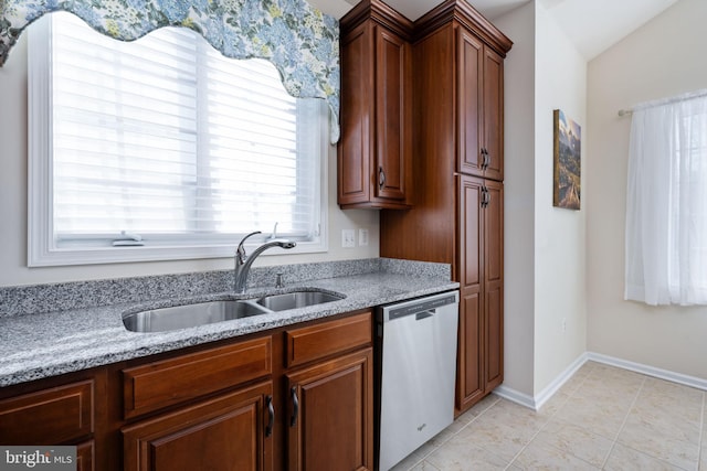 kitchen featuring dishwasher, sink, light stone counters, vaulted ceiling, and light tile patterned floors