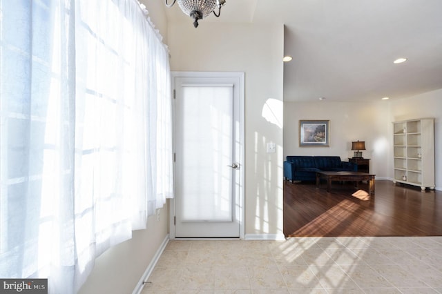 foyer with light hardwood / wood-style floors and an inviting chandelier