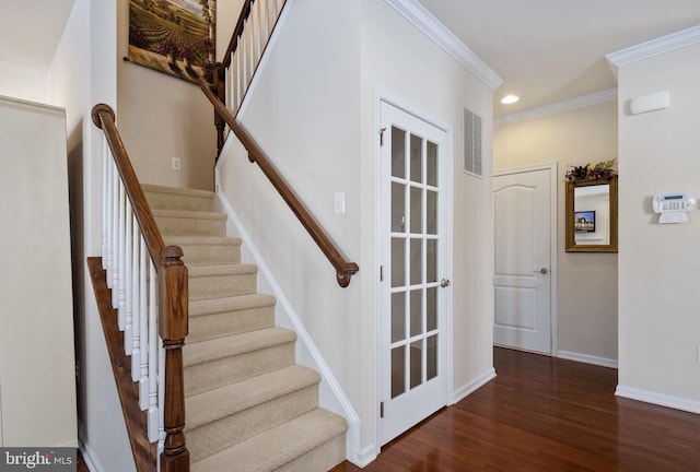 staircase with wood-type flooring and crown molding