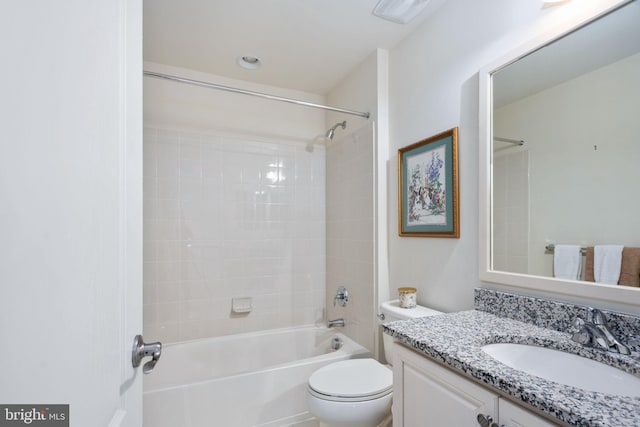 full bathroom featuring vanity, tiled shower / bath combo, and toilet