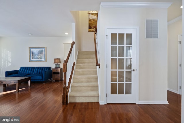 staircase featuring hardwood / wood-style floors and ornamental molding