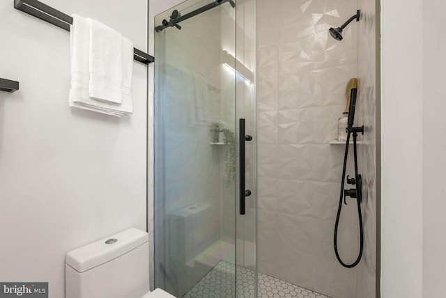 bathroom with toilet and a shower with door