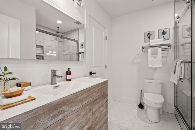 bathroom featuring toilet, vanity, tile patterned floors, and an enclosed shower