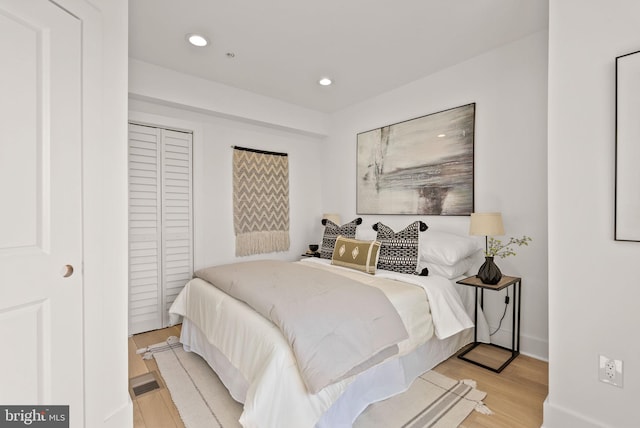 bedroom with a closet and light hardwood / wood-style flooring