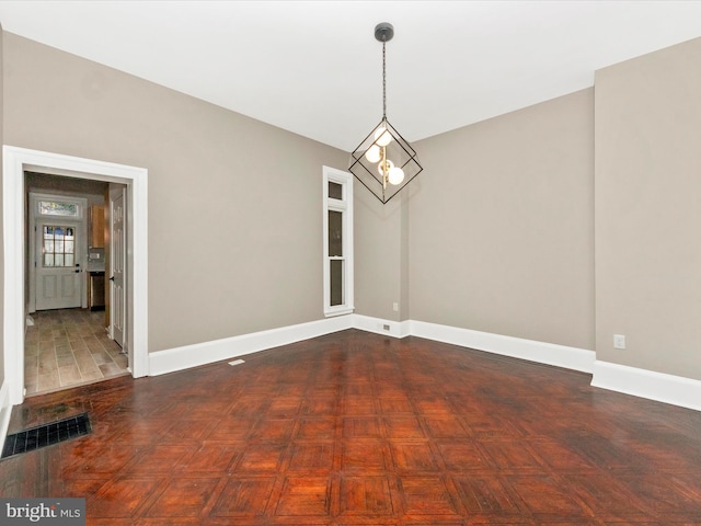 unfurnished dining area featuring a chandelier