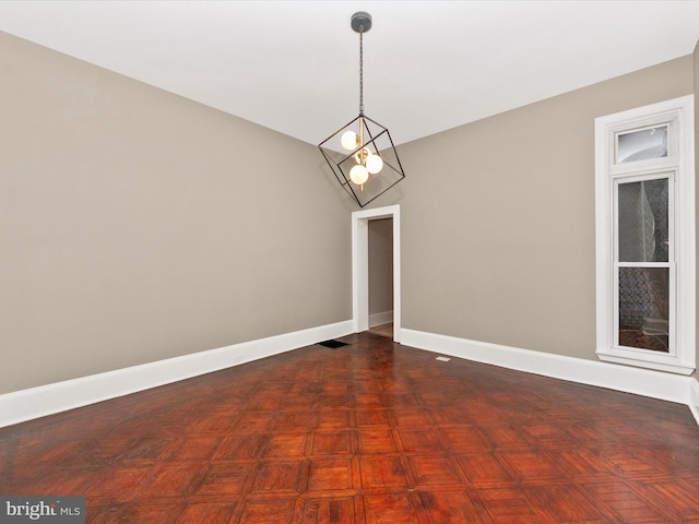 interior space with dark parquet flooring and an inviting chandelier