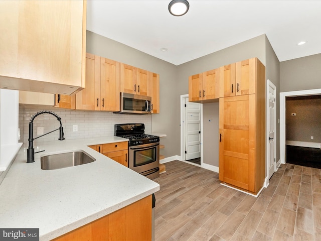 kitchen featuring sink, light hardwood / wood-style flooring, light brown cabinetry, tasteful backsplash, and stainless steel appliances