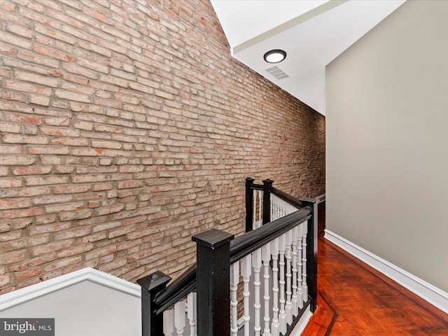 hallway with brick wall and parquet flooring