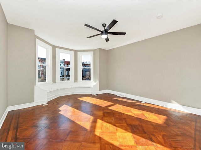 unfurnished room with ceiling fan and parquet floors