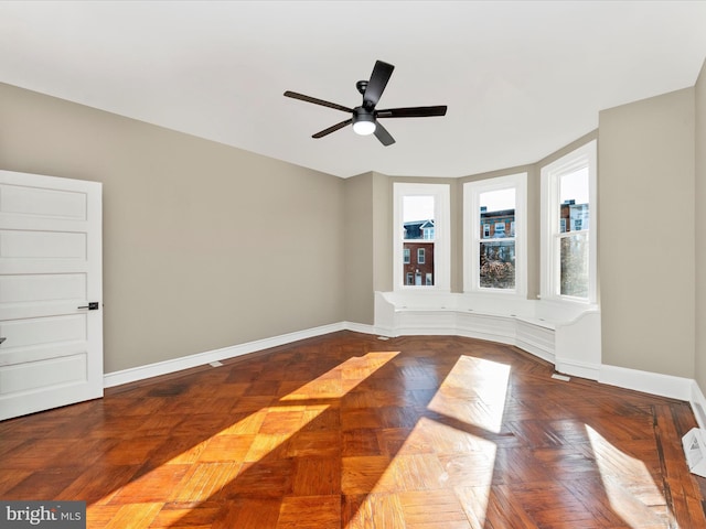 unfurnished room with ceiling fan and parquet floors