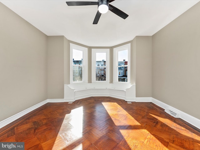 empty room with ceiling fan and parquet flooring