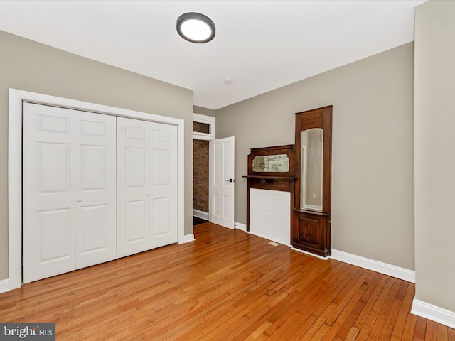 unfurnished bedroom with light hardwood / wood-style flooring and a closet