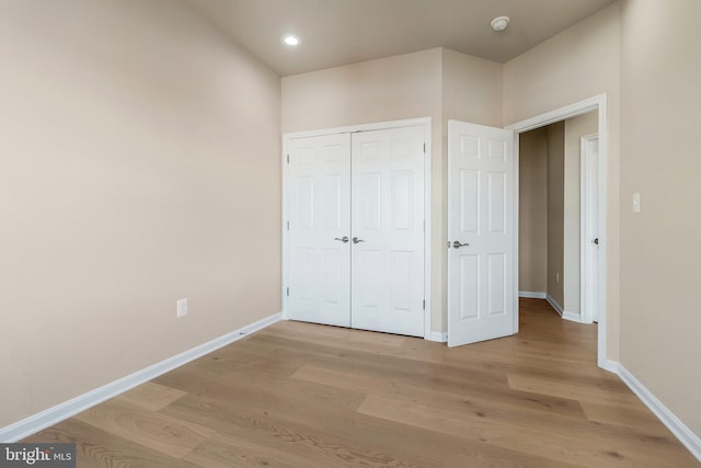 unfurnished bedroom featuring light hardwood / wood-style floors and a closet