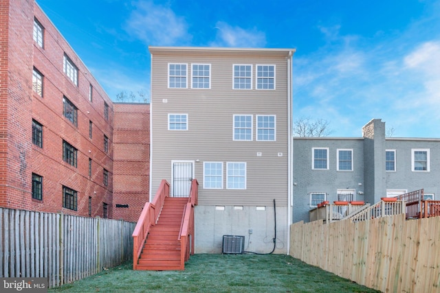 back of house with cooling unit and a yard