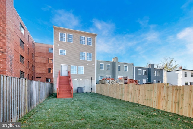 back of property with a lawn and cooling unit