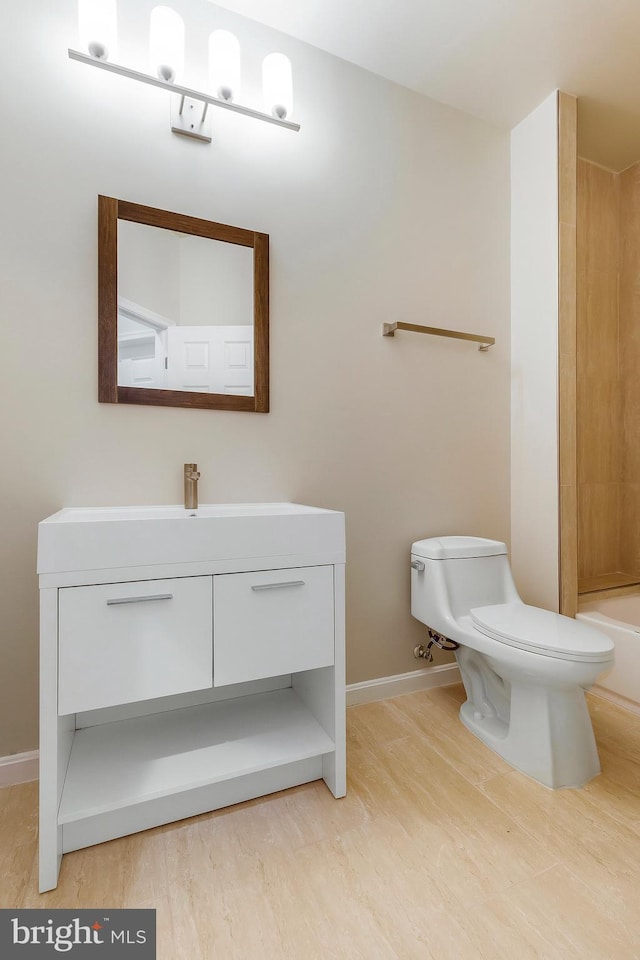 full bathroom featuring hardwood / wood-style floors, vanity,  shower combination, and toilet