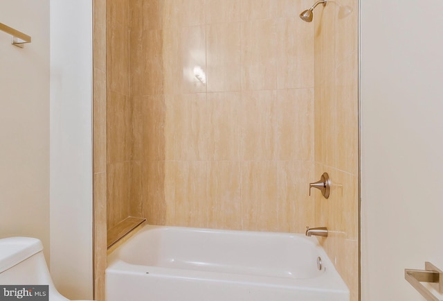 bathroom featuring tiled shower / bath and toilet