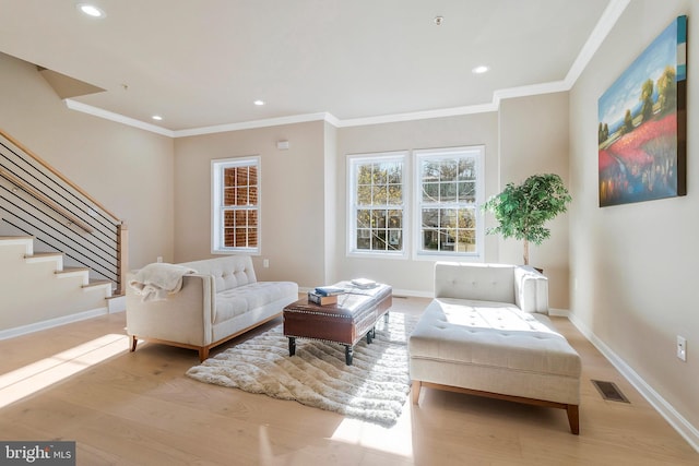 living area with light wood-type flooring and crown molding