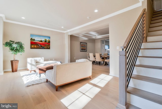 living room with light hardwood / wood-style flooring and crown molding