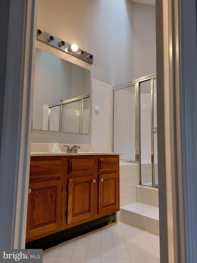 bathroom featuring vanity, a shower with door, and tile patterned floors