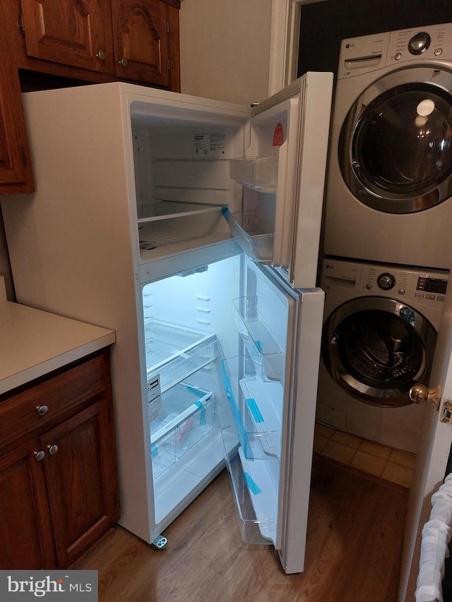 laundry area featuring stacked washer and dryer and light hardwood / wood-style floors