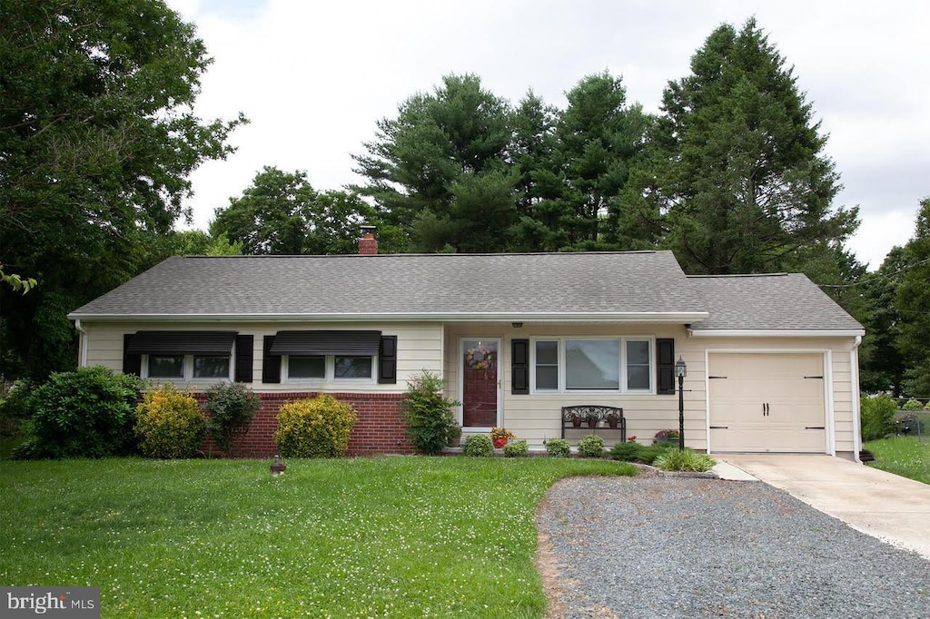 ranch-style home featuring a front lawn and a garage