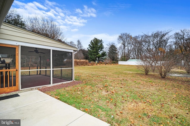 view of yard featuring a sunroom, ceiling fan, and a patio