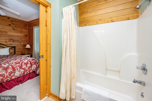 interior space featuring ceiling fan and wooden walls