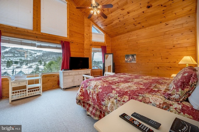 bedroom featuring wooden walls, ceiling fan, carpet floors, and high vaulted ceiling