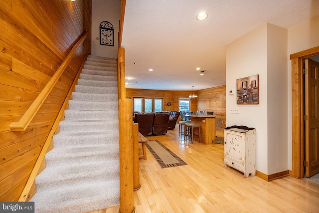 stairway with wood-type flooring and wood walls