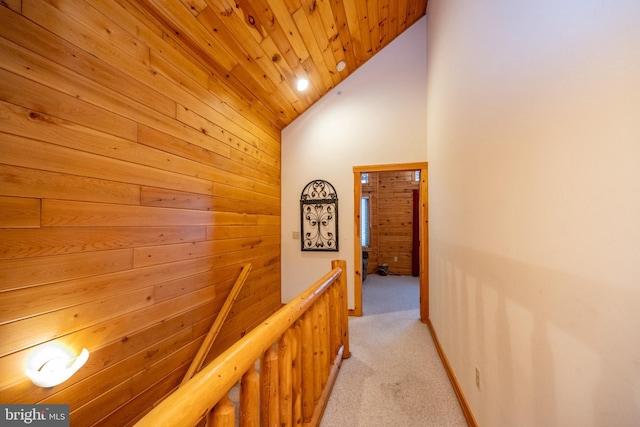 corridor featuring light carpet, high vaulted ceiling, and wooden ceiling