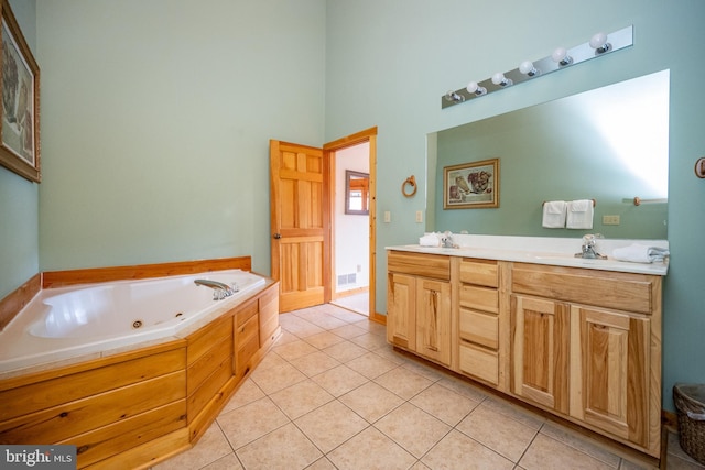 bathroom featuring a high ceiling, vanity, tile patterned floors, and a tub