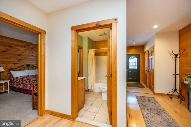 hallway featuring wooden walls and light hardwood / wood-style flooring