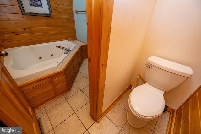 bathroom featuring tile patterned flooring, toilet, and a tub