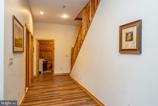 hallway featuring a textured ceiling and hardwood / wood-style flooring