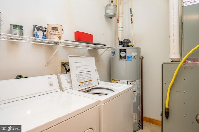 laundry area featuring washing machine and dryer, water heater, and light tile patterned floors