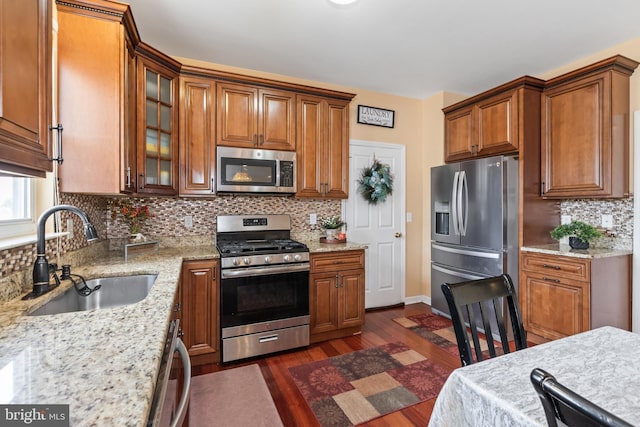 kitchen with backsplash, sink, stainless steel appliances, and dark hardwood / wood-style floors