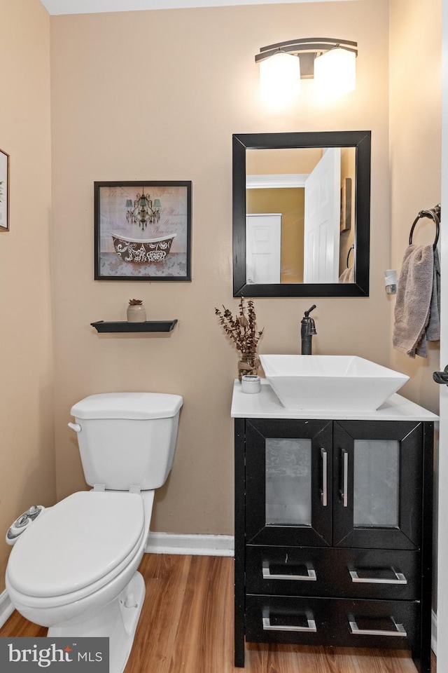 bathroom featuring toilet, vanity, and hardwood / wood-style flooring