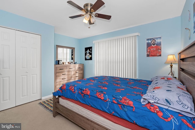 carpeted bedroom featuring ceiling fan and a closet