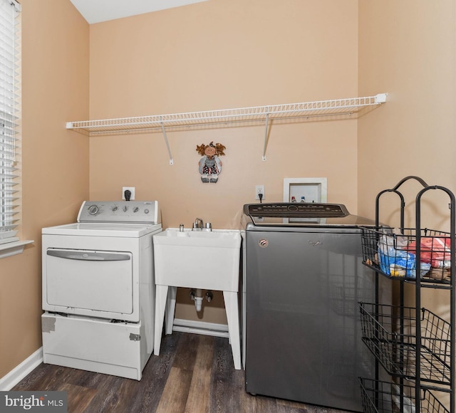 laundry room featuring dark hardwood / wood-style flooring, separate washer and dryer, and sink