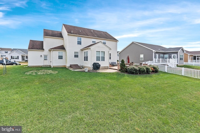 back of property with a lawn and a patio