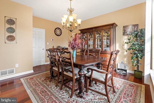 dining area with a chandelier and dark wood-type flooring