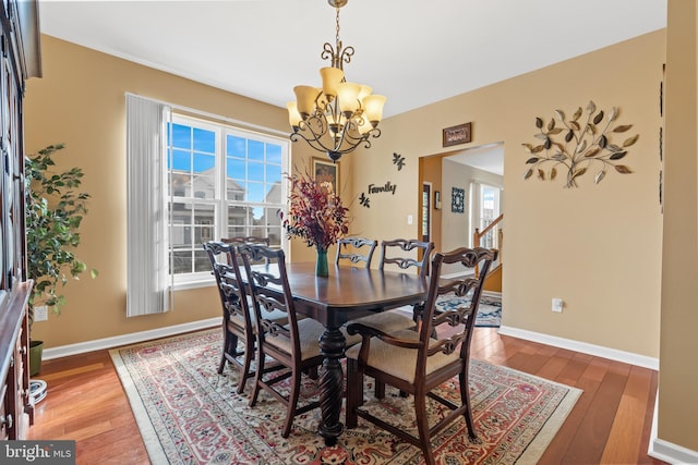 dining area with a chandelier and dark wood-type flooring