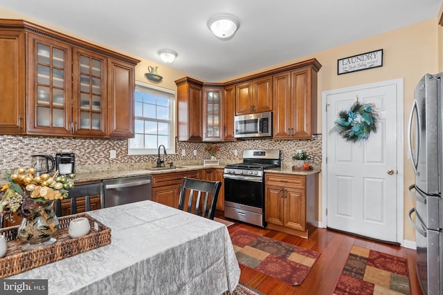 kitchen featuring decorative backsplash, sink, appliances with stainless steel finishes, and dark wood-type flooring