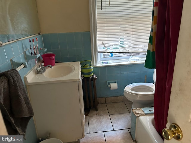 full bathroom featuring tile patterned floors, shower / bath combination with curtain, toilet, vanity, and tile walls