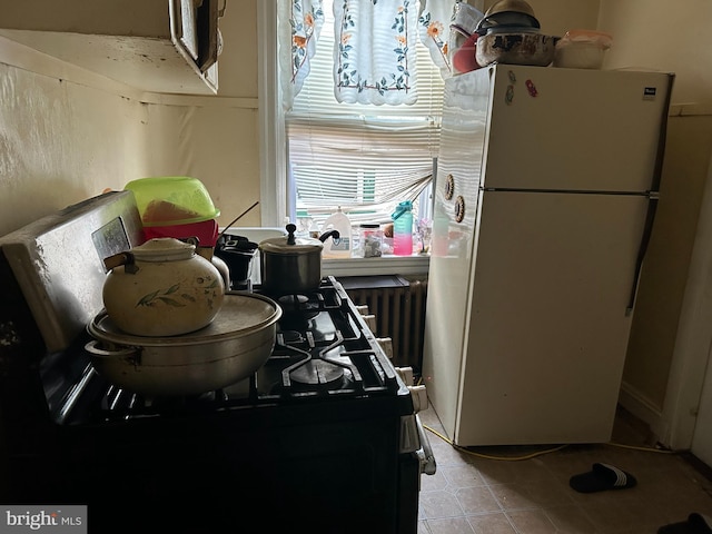 kitchen with white refrigerator and radiator