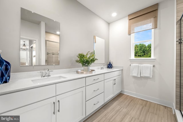 bathroom featuring vanity, wood-type flooring, and a shower with door