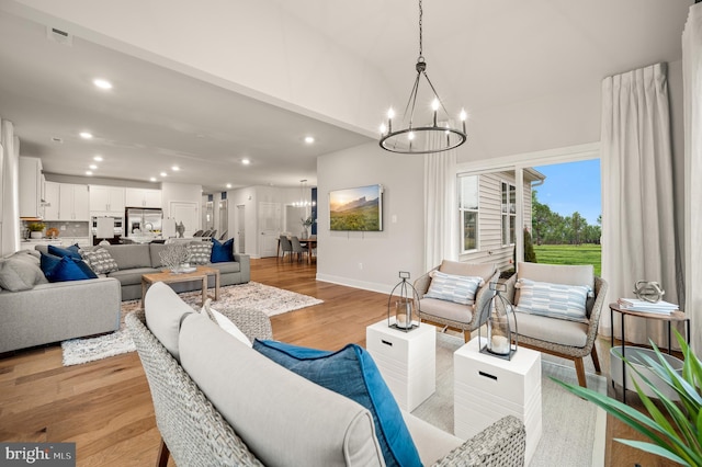 living room with light hardwood / wood-style flooring and a notable chandelier