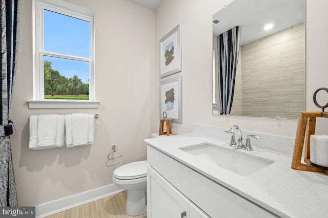 bathroom with hardwood / wood-style floors, vanity, and toilet